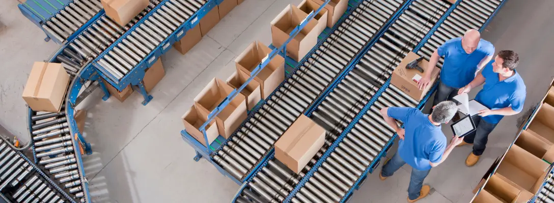 Employees reviewing boxes being shipped in a factory