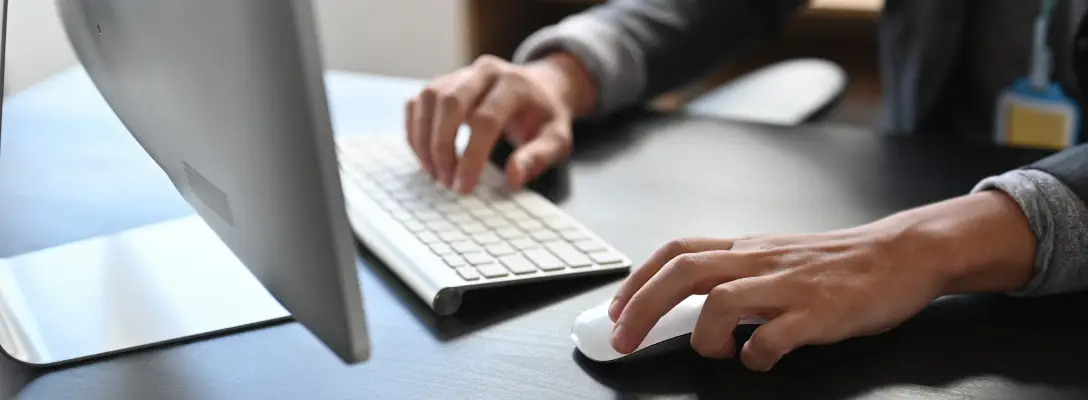 Person reviewing information on a white computer