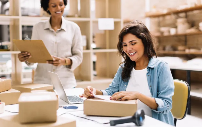 woman applying shipping label to parcel